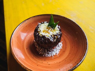 Chocolate coconut pineapple round dessert. Yellow table