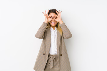 Young caucasian business woman isolated showing okay sign over eyes