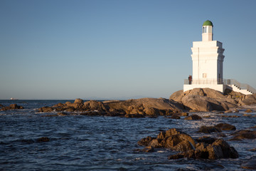 St Helena Bay, Cape Town, South Africa - August 26 2017: White Light House on the beach with ocean and rocks in the foreground in St Helena Bay West Coast Cape Town South Africa