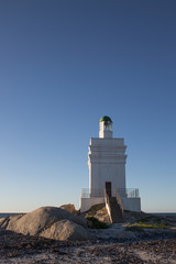 St Helena Bay, Cape Town, South Africa - August 26 2017: White Light House on the beach with ocean and rocks in the foreground in St Helena Bay West Coast Cape Town South Africa
