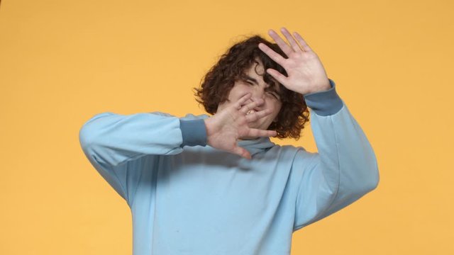 Stop it please, oh gosh. Slow-motion alarmed, embarrassed and disgusted curly-haired funny guy, cringe from aversion, covering eyes with hands, trying unsee something bad, seeing ugly naked man