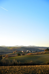 Fototapeta na wymiar farm in the hills in the warm light of sunset. Countryside and agriculture in winter