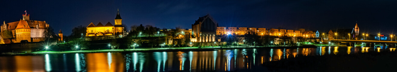 Fototapeta na wymiar River Nogat and Malbork city by night - panoramic view - Malbork, Pomerania, Poland