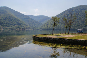Obraz premium calm beautiful lake surrounded by forests and tourist boats. Sights of Bosnia and Herzegovina.