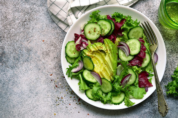 Fresh vegetable salad with avocado and cucumber. Top view with copy space.