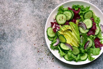 Fresh vegetable salad with avocado and cucumber. Top view with copy space.