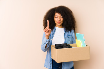 Young afro woman moving home isolated Young afro woman showing number one with finger.