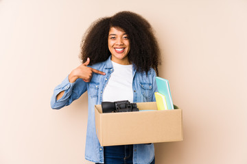 Young afro woman moving home isolated Young afro woman person pointing by hand to a shirt copy space, proud and confident