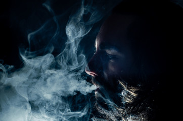 Smoking man exhaling a lot of vape smoke, with copy space.