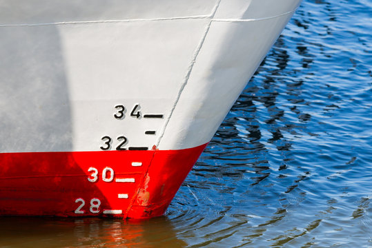 Red and white ship hull with waterline and draft scale measure