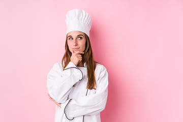 Young caucasian chef woman isolated looking sideways with doubtful and skeptical expression.