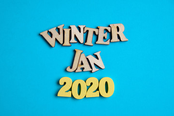 The concept of winter - January in the new year. Wooden numbers 2020 with letters on a blue...