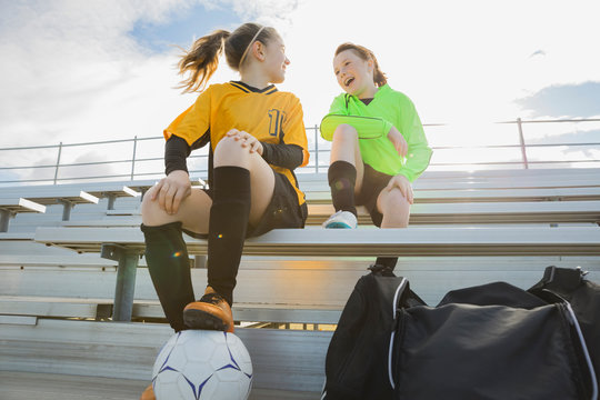 Girls In Soccer Uniforms Sitting On Bleachers