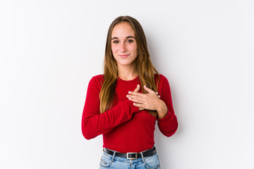 Young caucasian woman posing isolated  has friendly expression, pressing palm to chest. Love concept.