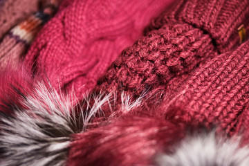 Woolly winter texture red hats on the counter in the store.
