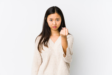 Young chinese woman isolated showing fist to camera, aggressive facial expression.