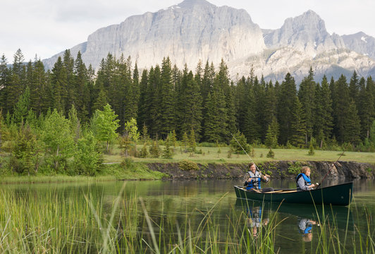 Father and son fishing in canoe in lake