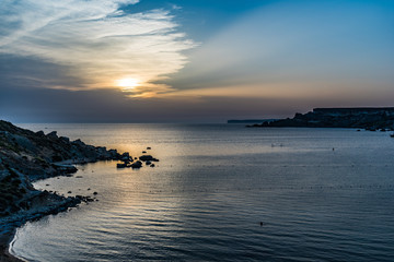 Fantastic sunset in the bay with sun rays on the blue sky