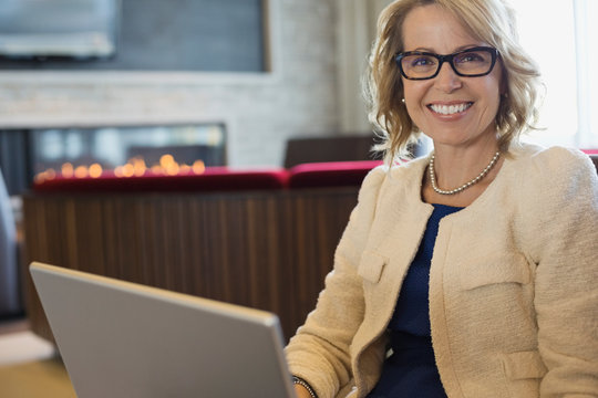 Portrait Of Happy Businesswoman Sitting In Hotel Lobby