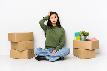 Young chinese woman moving to a new home being shocked, she has remembered important meeting.