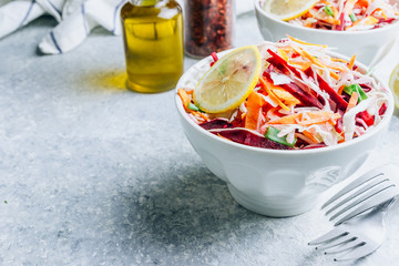 Spring healthy vegan salad with raw beet, carrot and cabbage in white bowls. Alkaline Diet concept. Selective focus