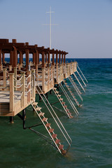 Badesteg am Strand ragt weit in das Meer