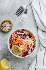 Spring healthy vegan salad with raw beet, carrot and cabbage in white bowls. Alkaline Diet concept. Top view. Flat lay