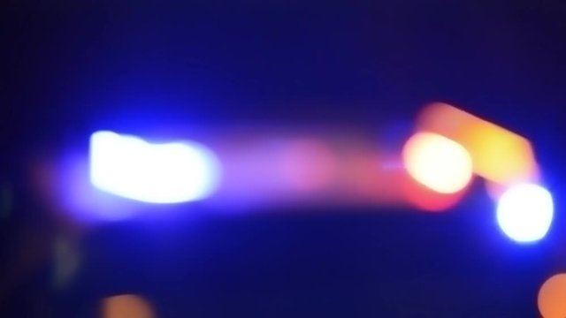 defocused video of the sires of a police squad car outside