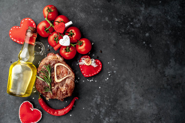 grilled steak, with tomatoes and spices with different red hearts on a stone background. with copy space for your text. Valentine's day dinner concept