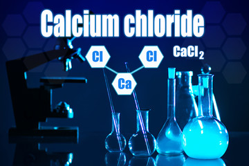 Chemical glassware and microscope against a dark background. Conducting research under a...