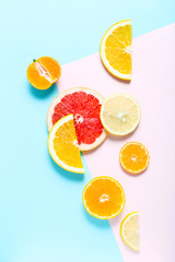 Sliced orange, grapefruit and tangerines on colorful background. Top view