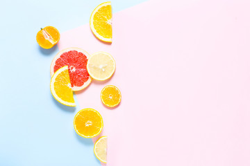 Sliced orange, grapefruit and tangerines on colorful background. Top view