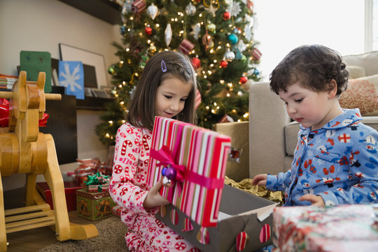 Siblings opening Christmas gift at home