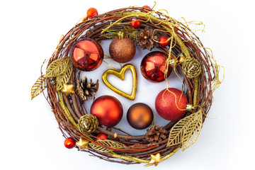 A shiny Christmas wreath made of dried twigs, decorated with balls and other decorations.