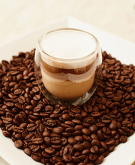 A cup of coffee in coffee beans. Coffee background