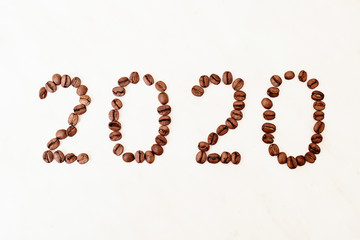2020 made from coffee beans. Grains on a white table.