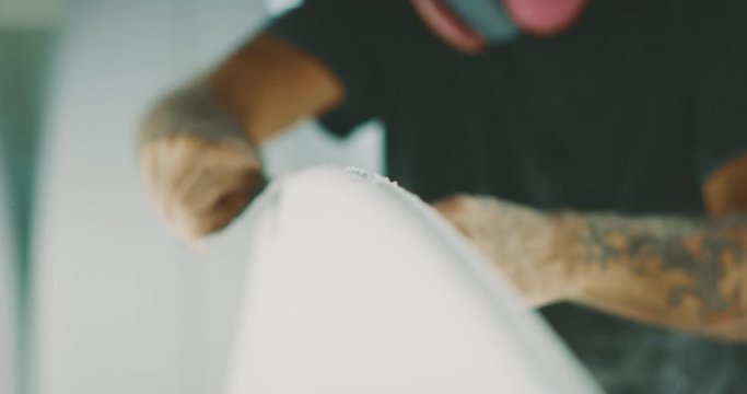 Surfboard shaper shaping a new surfboard with skill and precision, craftsman surfboard shaper working with his hands