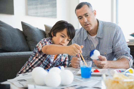 Father and son painting solar system model at home