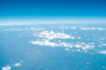 Fluffy white cloud with blue sky above view from airplane