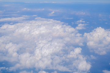 Obraz na płótnie Canvas Fluffy white cloud with blue sky above view from airplane
