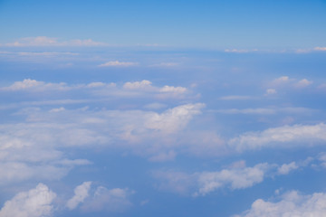 Fluffy white cloud with blue sky above view from airplane