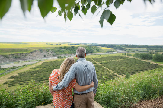 Hugging couple looking at view of countryside