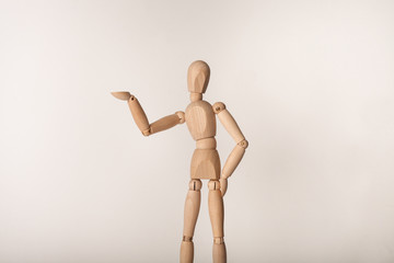 Wooden jointed manikin doll standing one hand on his hip other hand up in the air 