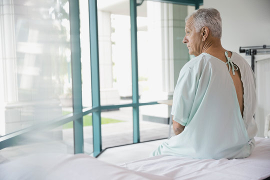 Thoughtful senior patient sitting on hospital bed