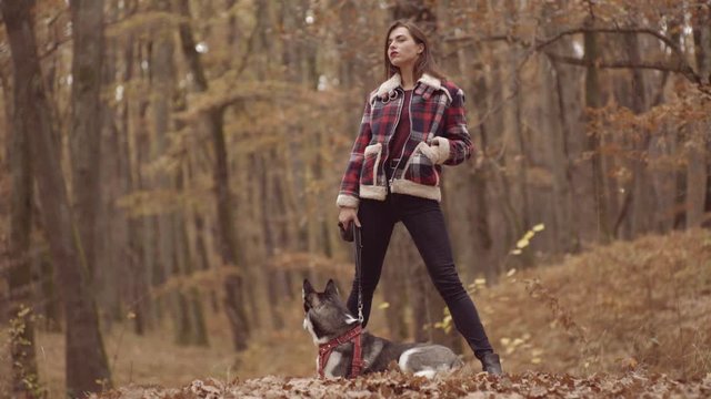 Girl with husky dog in uatumn park outdoors. Concept friendship with dog. Autumn girl plays with a dog (husky).