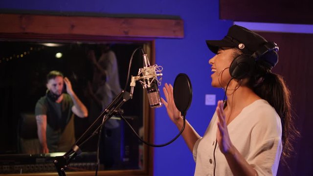 4K: Female Singer / Popstar recording an Album in the studio - With male Sound Engineer mixing the track behind