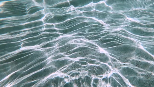 mesmerizing natural pattern of sunlight reflection underwater on the sand