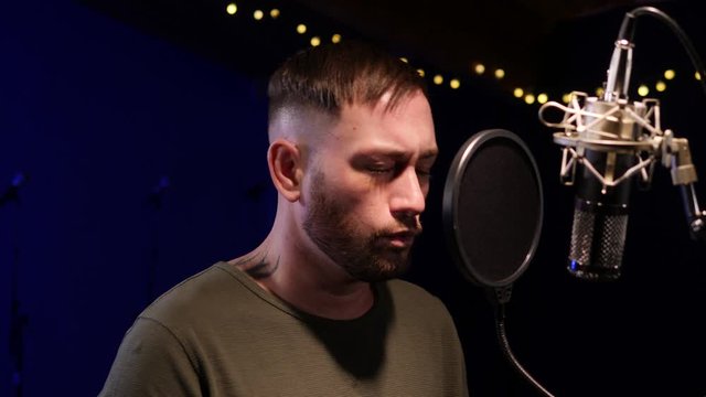 Male Singer / Popstar recording an Album in the studio - He sings into the Microphone & Popshield&nbsp;
