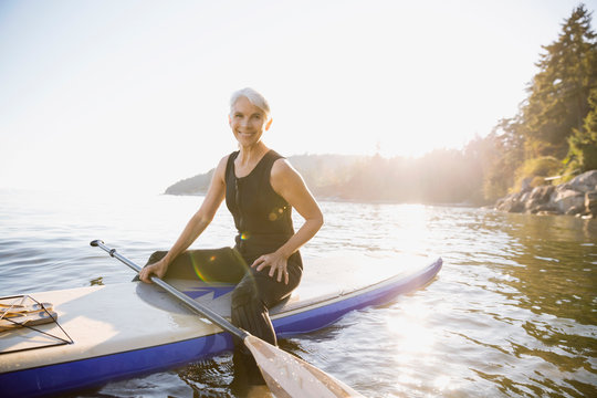 Senior Woman On Paddle Board In Ocean