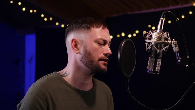 Passionate Male Singer / Popstar recording an Album in the studio - He sings into the Microphone & Popshield&nbsp;